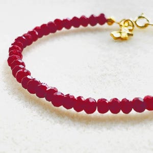 May include: A white ceramic mug with a black handle and the text "But First, Coffee" in a bold, black font. The mug is set against a neutral background, highlighting its simple design.