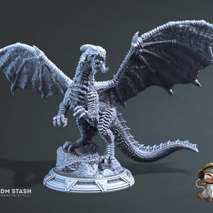 Könnte beinhalten: Eine detaillierte, graue, 3D-gedruckte Miniatur eines Drachen mit ausgebreiteten Flügeln. Der Drache steht in einer stehenden Position mit dem Kopf zur Seite gedreht und dem Maul offen. Der Drache steht auf einem runden Sockel mit einem erhabenen, strukturierten Design.