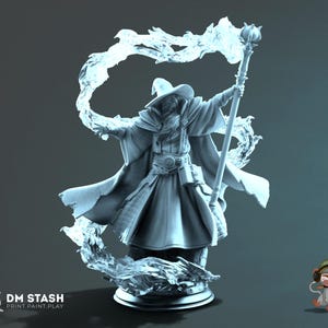 Peut inclure: Une figurine monochrome bleu clair représentant un magicien portant un chapeau à larges bords et de longues robes, tenant un grand bâton. Des effets d'énergie magique translucides tourbillonnent autour. Le texte DM STASH PRINT.PAINT.PLAY est visible.