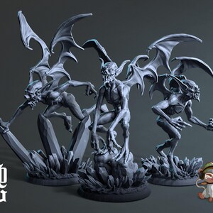 May include: Three grey gargoyle figurines with large, detailed wings and menacing expressions. Each figure is posed on a rocky base, with one perched and two in dynamic stances. The figures are detailed with sharp claws and teeth.