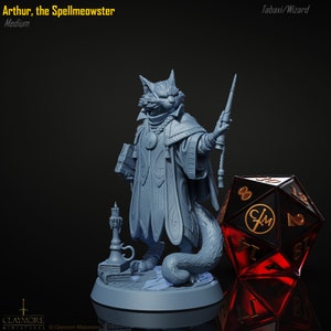 Peut inclure: Une figurine miniature peinte en gris d'une créature féline portant une robe et tenant un bâton. La créature a un livre dans sa main gauche et une longue queue. La figurine est debout sur une base ronde avec une bougie et des livres. La figurine est à côté d'un dé rouge et noir à 20 faces.