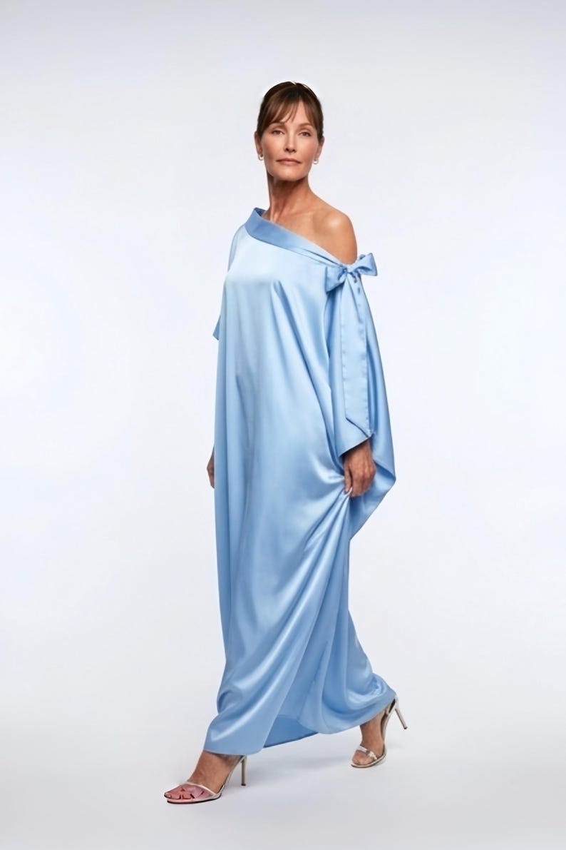 Flowy blue kaftan maxi dress with off shoulder neckline and self-tie bow, shown as a loose handmade vacation dress for women.
