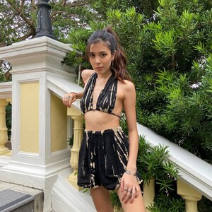 May include: A black and white tie-dye halter top and matching shorts. The top has a deep V-neckline and the shorts have a high waist.