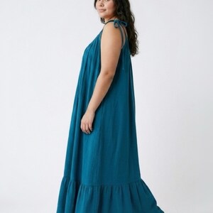 Blue turquoise open back maxi dress with tie shoulders and a flowy oversized fit on the beach.