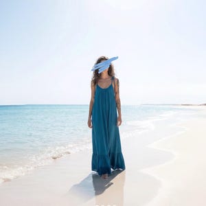 Blue turquoise open back maxi dress with tie shoulders and a flowy oversized fit on the beach.