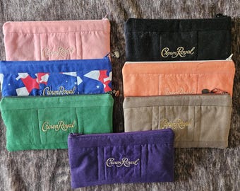 Op de afbeelding: Een set van tien Crown Royal-tasjes in verschillende kleuren en patronen. De tasjes zijn gemaakt van een zachte, gestructureerde stof en hebben het Crown Royal-logo geborduurd in goud.
