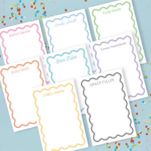 May include: A selection of personalised stationery cards with scalloped borders in a range of colours, including pink, blue, green, orange, yellow, and grey. Each card displays a name, such as "Emily Smith" or "Grace Fuller", printed in a matching colour.