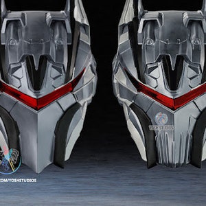 May include: A silver and black robot helmet with red glowing eyes. The helmet has a sharp, angular design with intricate details.