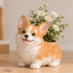 May include: A ceramic planter shaped like a Corgi dog with a tan and white coat, featuring a glossy finish, a smiling expression with a pink tongue, and a hollow back section containing a bouquet of white daisies with yellow centers.