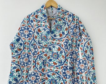 Könnte beinhalten: Weiße Jacke mit blauem, türkisfarbenem und orangefarbenem Blumenmuster. Die Jacke hängt an einem Holzbügel vor weißem Hintergrund. Sie hat einen Kragen und eine Knopfleiste.