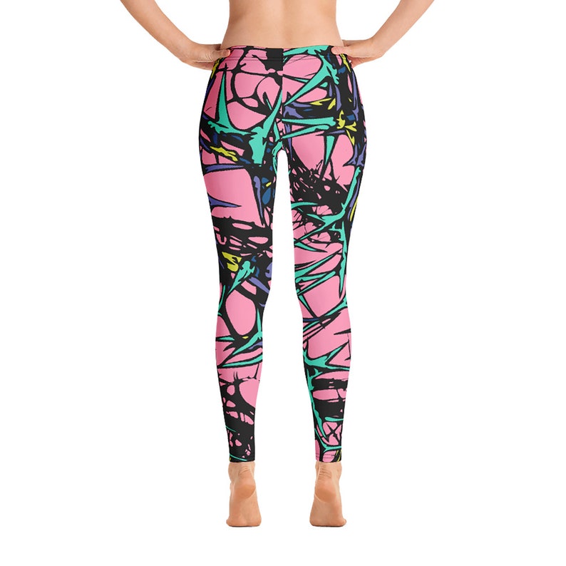 Puede incluir: Leggins rosas con un patr&oacute;n abstracto negro, azul, verde y amarillo. El patr&oacute;n se asemeja a espinas o ramas.