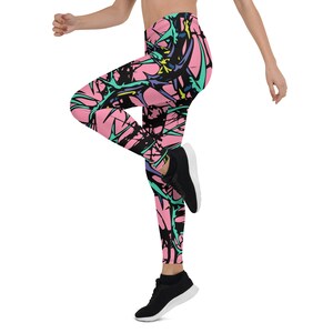 Puede incluir: Leggins rosas con un estampado abstracto en negro, azul y verde. Los leggins tienen cintura alta y un ajuste ce&ntilde;ido.