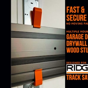 May include: A silver track saw guide rail with orange clips. The rail is mounted to a wall and the text "FAST & SECURE NO MOVING PARTS" is printed above the rail. The text "MULTIPLE MOUNTING GARAGE DOOR DRYWALL WOOD STUDS" is printed below the rail. The text "DESIGNED FOR RIDGID TRACK SAW" is printed below the rail.