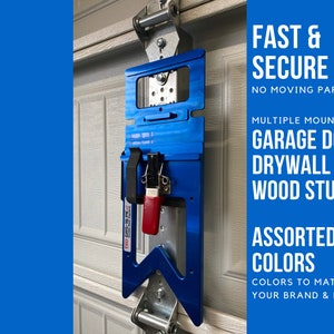 May include: A blue garage door opener mounting bracket with a red release lever. The bracket is designed to be mounted to a garage door, drywall, or wood studs. The text "FAST & SECURE" is printed in white on a blue background. The text "NO MOVING PARTS" is printed in white on a blue background. The text "MULTIPLE MOUNTING" is printed in white on a blue background. The text "GARAGE DOOR" is printed in white on a blue background. The text "DRYWALL" is printed in white on a blue background. The text "WOOD STUDS" is printed in white on a blue background. The text "ASSORTED COLORS" is printed in white on a blue background. The text "COLORS TO MATCH YOUR BRAND & MORE" is printed in white on a blue background.