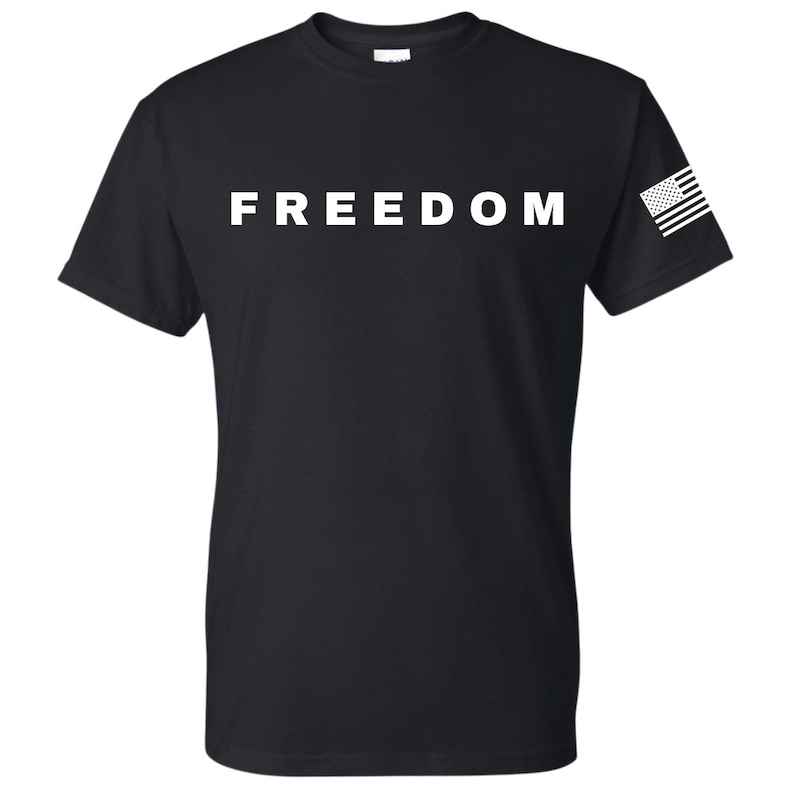 May include: Black t-shirt with the word "FREEDOM" printed in large white letters across the chest. A small American flag is printed on the left sleeve.