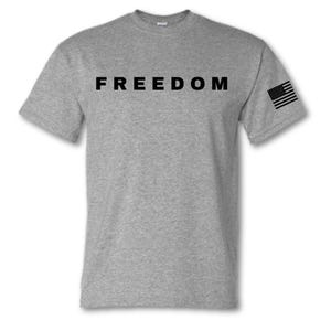 May include: A heather gray t-shirt with the word "FREEDOM" printed in black across the chest. An American flag graphic is on the left sleeve. The shirt is a crew neck style.