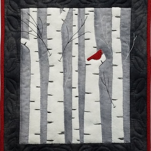 Peut inclure: Un cardinal rouge perché sur une branche dans une forêt de bouleaux enneigée. Les arbres sont blancs avec des marques noires et les branches sont nues.