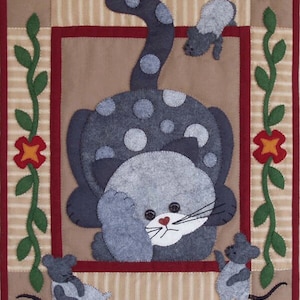 May include: A gray cat with white spots is curled up on a tan background. The cat is looking to the right. Three gray mice are around the cat. The background is a tan and white striped fabric with a red border.