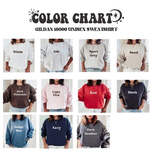 May include: Color chart showing 12 different colors of Gildan 18000 unisex sweatshirts. The colors are: White, Ash, Sport Grey, Sand, Dark Chocolate, Light Pink, Red, Black, Indigo Blue, Navy, Dark Heather.