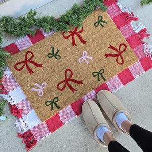 Juldörrmatta med kokettmotiv, dörrmatta med god jul, dörrmatta med flickig julkärna, estetisk dörrmatta med hårrosetter, dörrmatta med julstämning