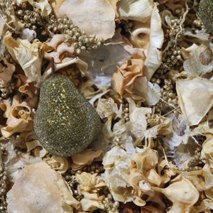 May include: A green pear-shaped potpourri with a glittery finish, surrounded by dried flower petals and other natural elements in shades of beige and brown.