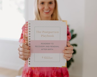 Könnte beinhalten: Ein spiralgebundenes Buch mit dem Titel "The Postpartum Playbook" mit goldenen Eckakzenten und einem rosa Band mit der Aufschrift "Roadmap to Recovery and Renewal After Birth". Das Buch wird vor einer Person in einem rosa Kleid gehalten.