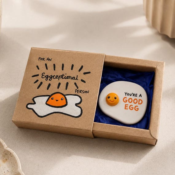 A handmade fried egg fridge magnet with a punny affirmation — tiny price, big smile, 229 favorites confirm it lands every time.