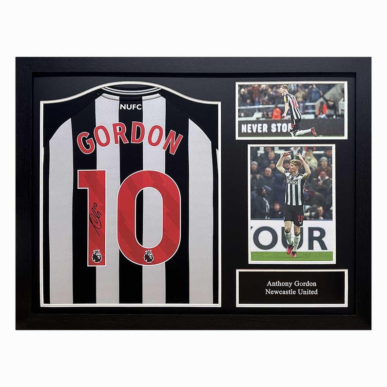 Op de afbeelding: Een ingelijst Newcastle United voetbalshirt met de naam "Gordon" en het nummer "10" op de rug. Het shirt is zwart-wit gestreept. De lijst bevat foto's van de speler in actie.
