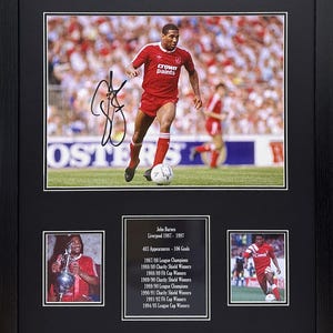 Può includere: Una foto incorniciata di John Barnes, un ex giocatore del Liverpool Football Club, che indossa una maglia rossa e bianca con la scritta "crown paints" sul davanti. La foto è firmata da John Barnes. La cornice include tre foto più piccole di Barnes che tiene trofei e gioca a calcio. Il testo sotto la foto principale dice "John Barnes, Liverpool 1987-1997, 403 Presenze - 106 Gol, Campioni di Lega 1987/88, Vincitori dello Scudo di Beneficenza 1988/89, Vincitori della Coppa FA 1988/89, Vincitori dello Scudo di Beneficenza 1989/90, Campioni di Lega 1989/90, Vincitori dello Scudo di Beneficenza 1990/91, Vincitori della Coppa FA 1991/92, Vincitori della Coppa di Lega 1994/95."
