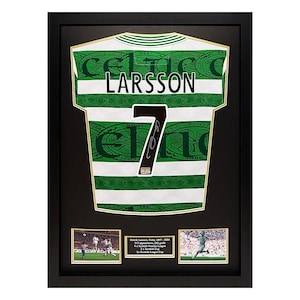 Op de afbeelding: Ingelijst Celtic voetbalshirt, wit met groene strepen, met "LARSSON" en nummer "7". Inclusief twee kleine foto's van de speler en de tekst "Henrik Larsson, Celtic 1997-2004". Een verzamelobject.