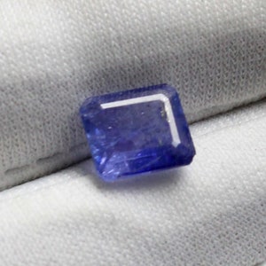 Könnte beinhalten: Ein tiefblauer Edelstein mit rechteckigem Schliff und leicht trübem Aussehen.