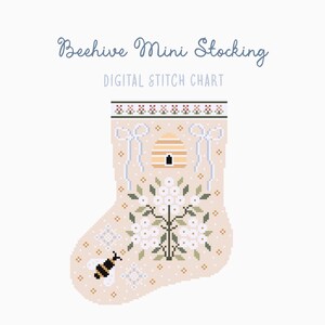 Puede incluir: Un gráfico de punto de cruz digital para un mini calcetín. El diseño presenta una colmena, flores y una abeja, con el texto "Beehive Mini Stocking" y "DIGITAL STITCH CHART". El calcetín es beige con detalles blancos y verdes.