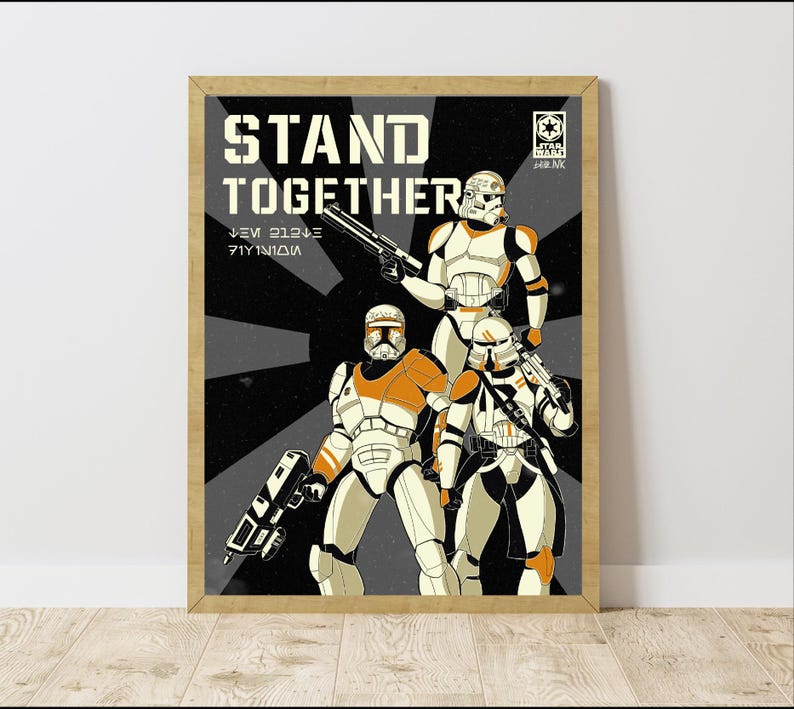 May include: A framed Star Wars poster with three clone troopers in white and orange armour, holding blasters. The poster has the words "STAND TOGETHER" in large letters, with a black and grey background.