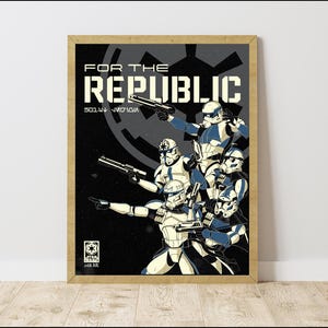 May include: Framed poster with a group of soldiers in white and blue armour, holding blasters. The words "FOR THE REPUBLIC" are at the top, with additional text and a logo at the bottom. The background is dark grey.