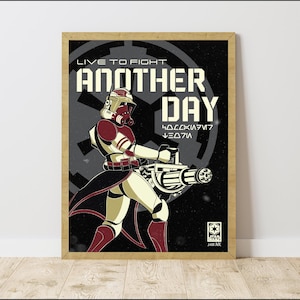 May include: Framed poster of a Star Wars clone trooper in red and white armour, holding a large weapon. The poster reads "LIVE TO FIGHT ANOTHER DAY" in white, with the Star Wars logo.