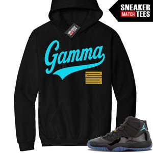 Pode incluir: Moletom preto com capuz com a palavra "Gamma" em escrita turquesa, uma sublinha turquesa e um design amarelo. Um par de tênis pretos e azuis estão na imagem. O moletom tem uma etiqueta que diz "Sneaker Match Tees".