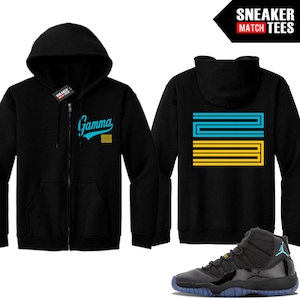 May include: Black zip-up hoodie with "Gamma" in teal script and yellow stripes. The back features a teal and yellow design. A black and blue sneaker is shown below the hoodie. The top right corner has the text "SNEAKER MATCH TEES".
