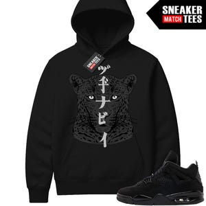 May include: Black hoodie featuring a detailed leopard face graphic with Japanese text. The hoodie has a drawstring hood and a kangaroo pocket. A pair of black sneakers is shown in the image. The brand name "SNEAKER MATCH TEES" is visible.