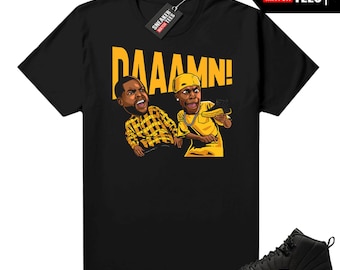 May include: Black t-shirt with a yellow graphic of two cartoon characters and the word "DAAAMN!". A pair of black and yellow sneakers is shown in the image. The shirt has a tag that says "SNEAKER MATCH TEES".