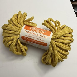 May include: A spool of yellow braided macramé cord. The label reads "EZ Knot Braided Macramé Cord" and indicates the cord is 100% texturized polypropylene, with 84-50 yards (45.7 meters).