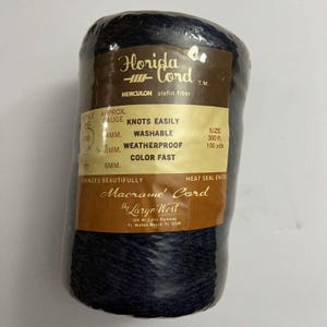 May include: A spool of dark navy blue Florida Cord macrame cord made of Herculon olefin fiber. The label indicates it is 300 feet long, knots easily, is washable, weatherproof, and color fast. The packaging includes the Largo West brand name.