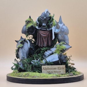 May include: A detailed figurine of Alphonse Elric from Fullmetal Alchemist, in a seated position, covered in moss. The figure is gray with a red cape and is mounted on a wooden base with a nameplate that reads "Alphonse Elric, Fullmetal Alchemist."