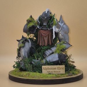 May include: A detailed figurine of Alphonse Elric from Fullmetal Alchemist. The figure is in a battle-worn state, with metallic armor, a red cloth, and patches of green moss. The base is a wooden circle with more moss and a nameplate.