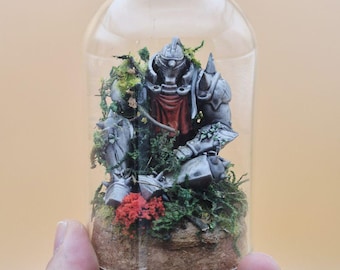 May include: A miniature figurine of an armored knight inside a glass dome. The knight is gray with a red cloth, surrounded by green moss and red flowers. The dome sits on a cork base.