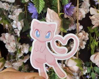 May include: Pink and white Pokemon sticker of a pink cat-like creature with a heart-shaped tail. The sticker is on a background of pink and purple flowers.