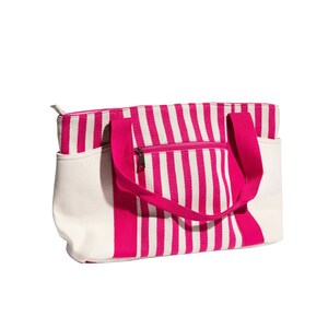 May include: A pink and white striped tote bag with a zippered pocket and two handles.