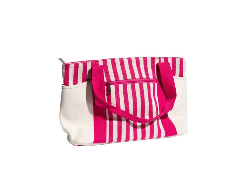 May include: A pink and white striped tote bag with a zippered pocket and two handles.
