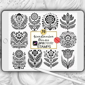May include: A digital tablet shows 70 Scandinavian flower stamps for Procreate. The black and white floral designs include stylized flowers and leaves. The tablet is on a white surface with a feather background.