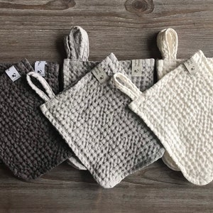 May include: Five waffle weave kitchen towels in different colors: gray, light gray, white, dark gray, and black. Each towel has a loop handle and a small tag with the text "Hand Made" on it.