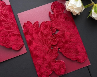 May include: A deep red invitation card featuring a laser-cut velvet overlay with an intricate floral pattern. The card has a rectangular shape with scalloped edges on the front panels, showcasing a rich crimson texture and a matte paper base.